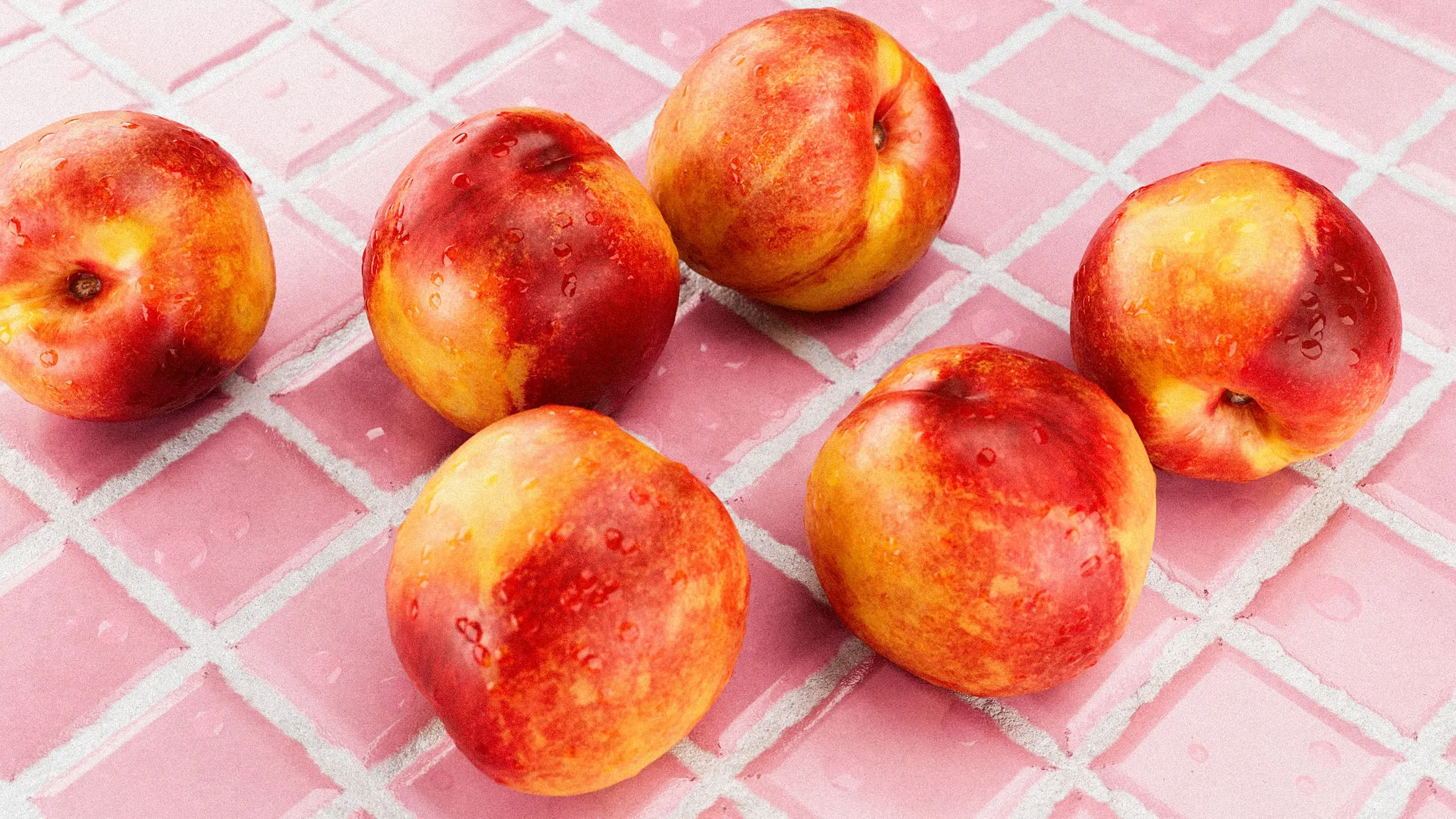 Close-up of nectarines on pink tiled background