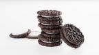 Stack of chocolate cookies with cream filling on a white background