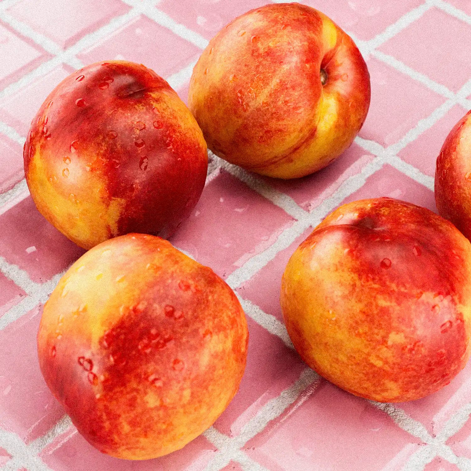 Four peaches on a pink checkered surface