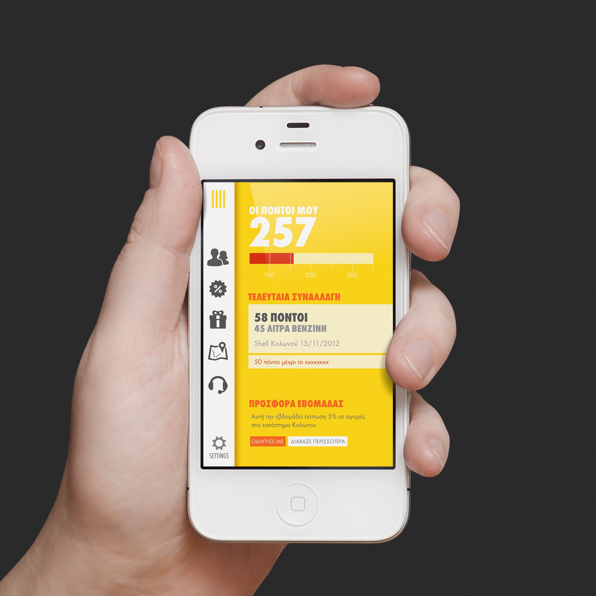 Hand holding a smartphone with a yellow and black app interface on a gray background